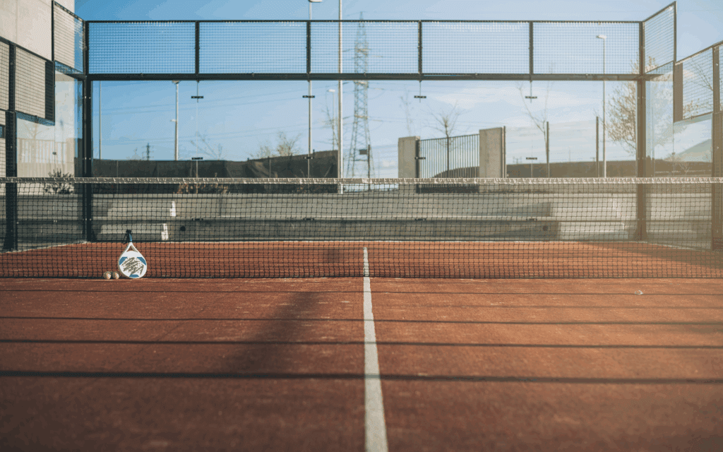 A bright yellow tennis ball resting on a green tennis court surface.