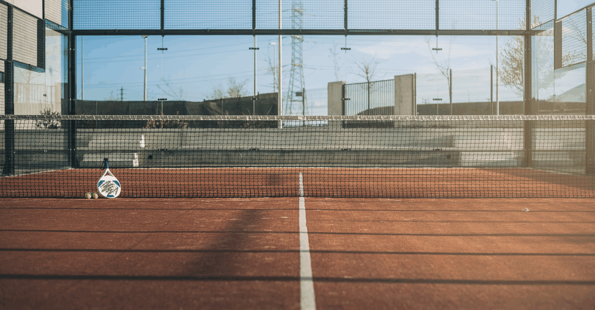 A bright yellow tennis ball resting on a green tennis court surface.