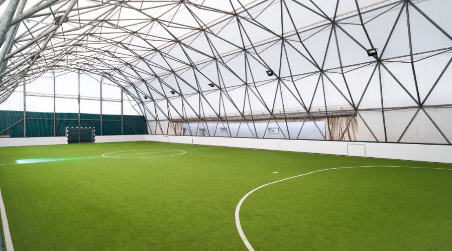 Indoor artificial turf field with concentrated sunlight hotspot caused by solar reflection from facility windows